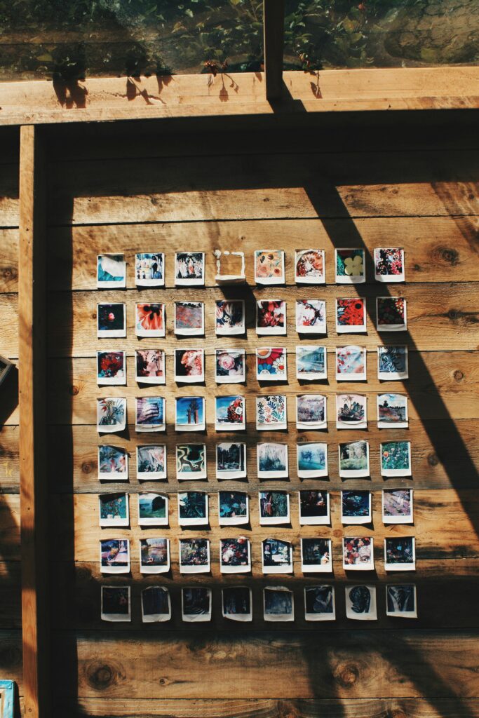 pexels photo 1128229 1128229 A charming display of instant photos on a wooden wall under sunlight in Chaumont-sur-Loire.